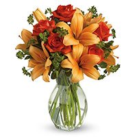 Online Diwali Flowers Delivery of Orange Lily Red Roses in Vase 12 Flowers to Hyderabad